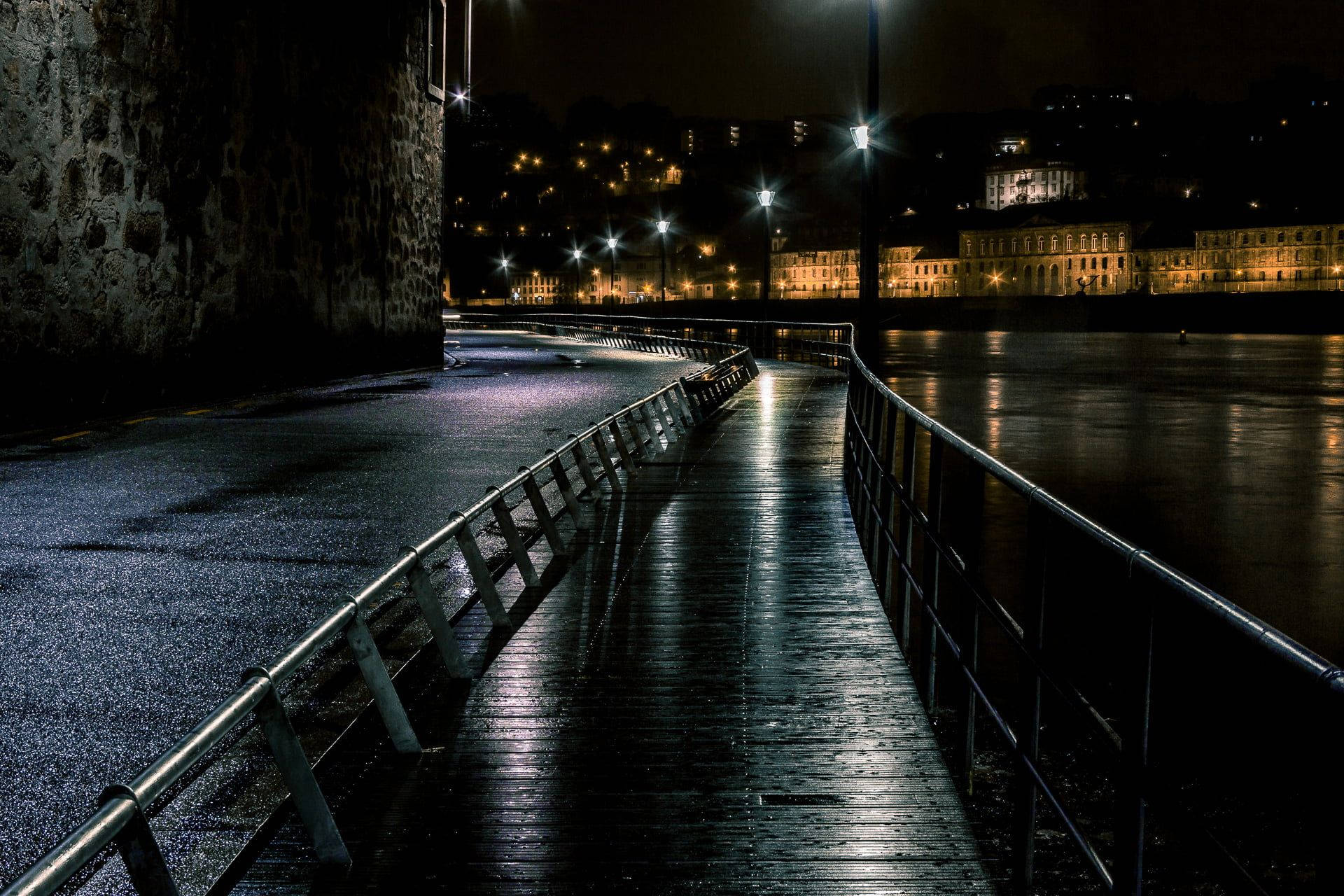 Riverside Walkway At Night Background