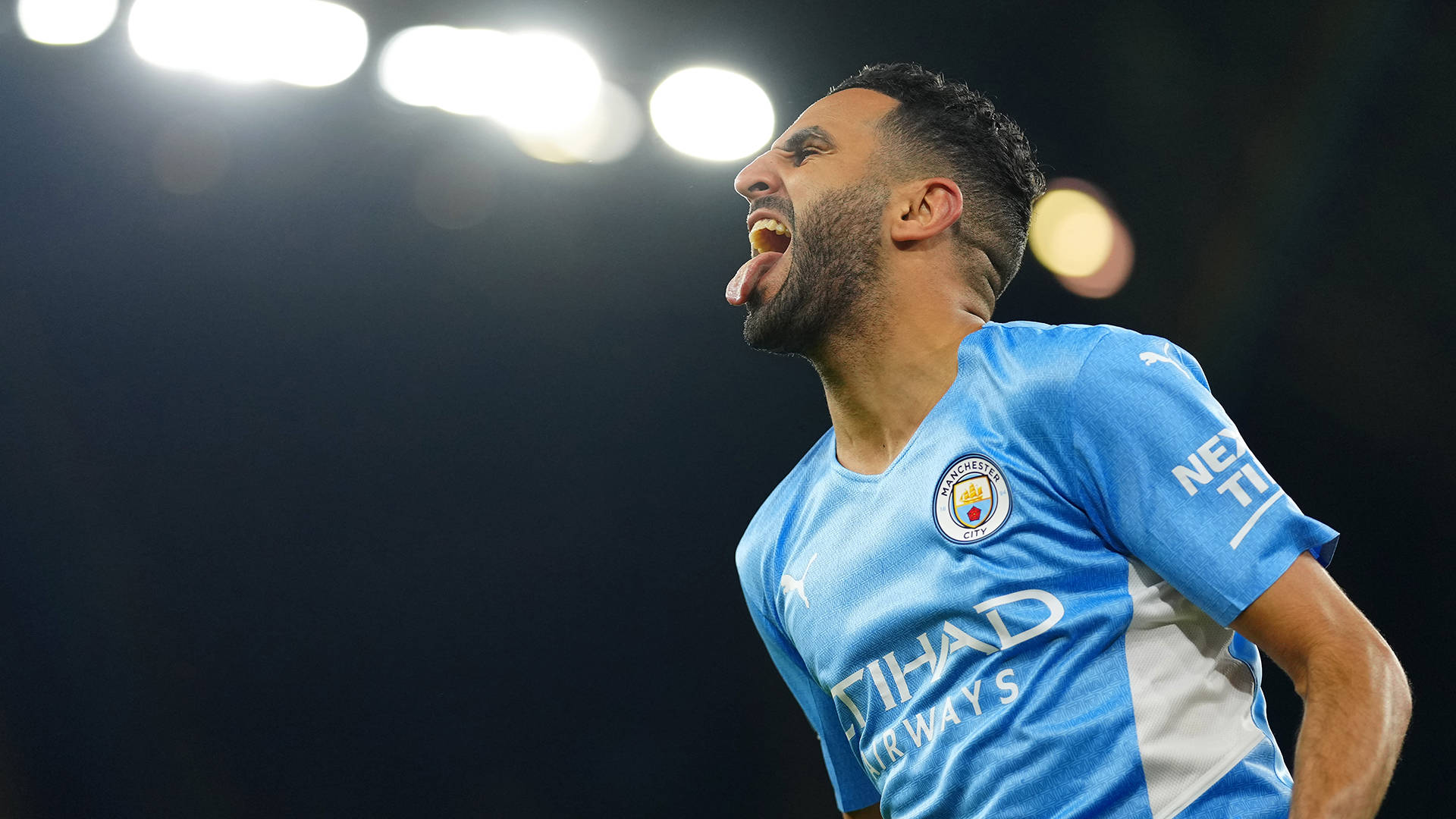 Riyad Mahrez Tongue Out Lights Background