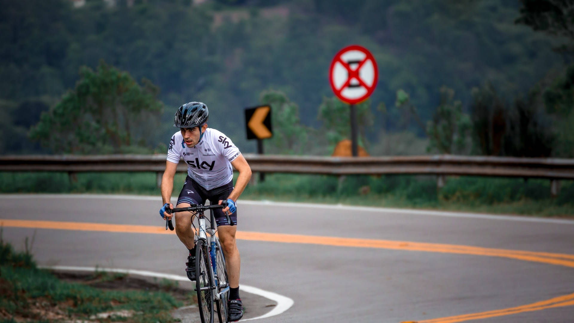 Road Bike Rider In Curvy Road Background