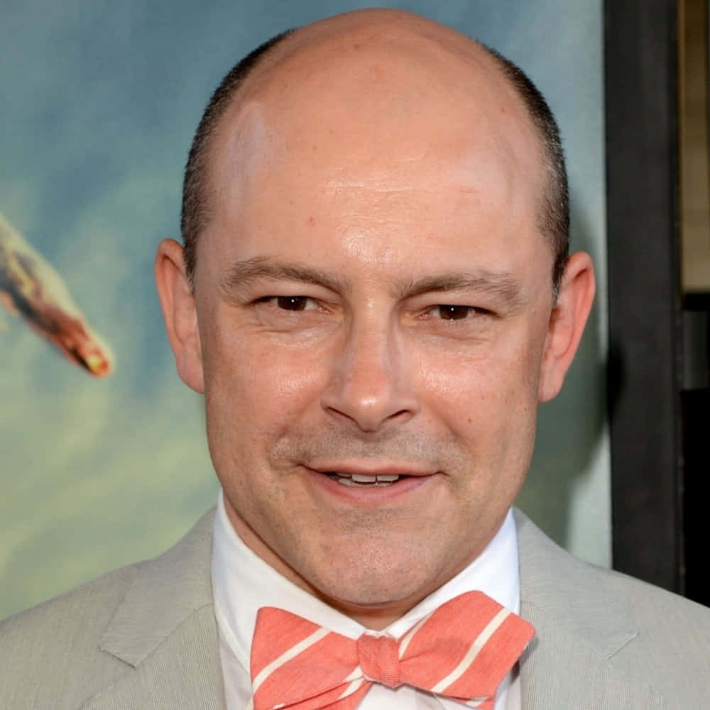 Rob Corddry Smiles With A Bright Beach Backdrop Background