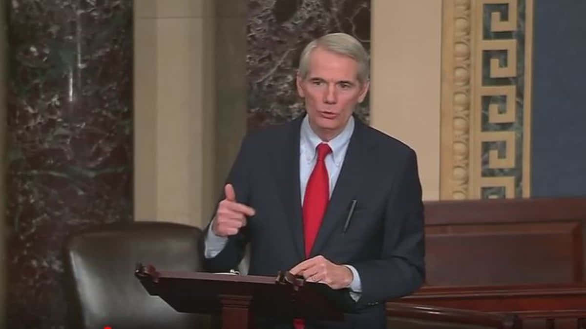 Rob Portman Passionately Discussing A Point During A Meeting Background