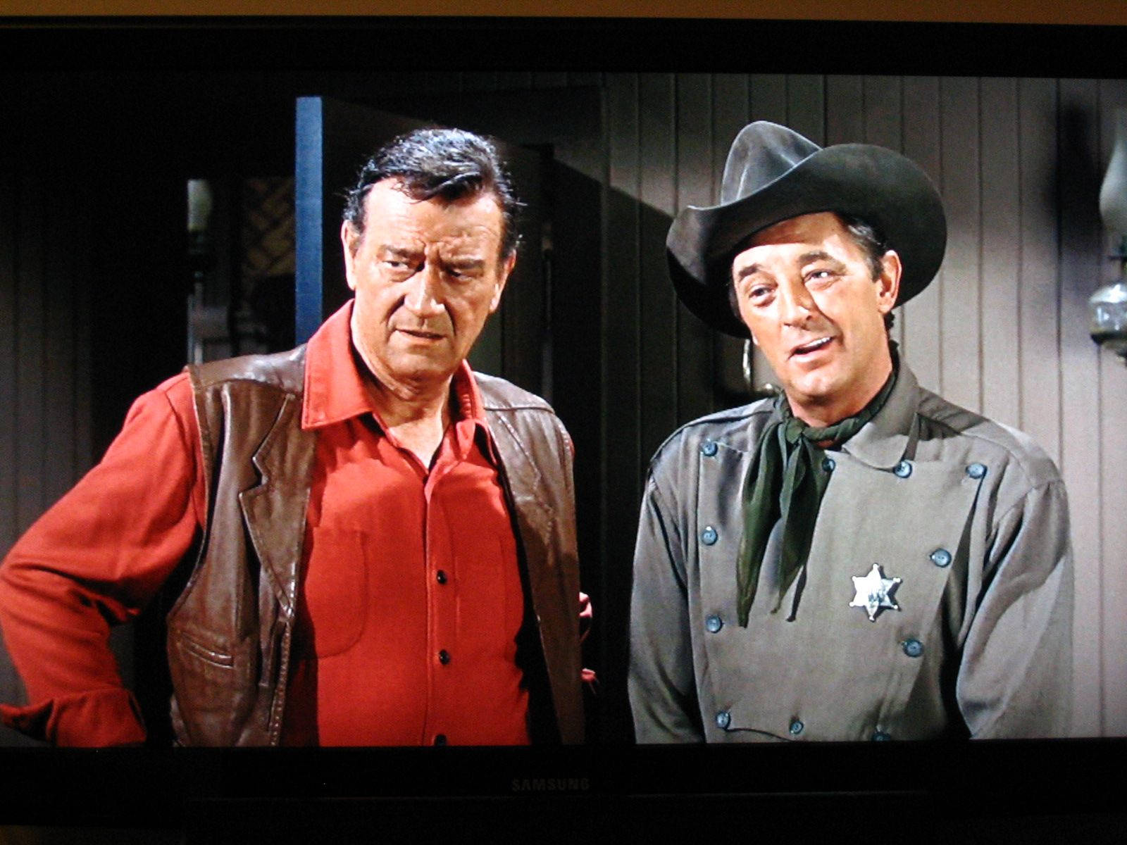 Robert Mitchum And John Wayne In Movie Background