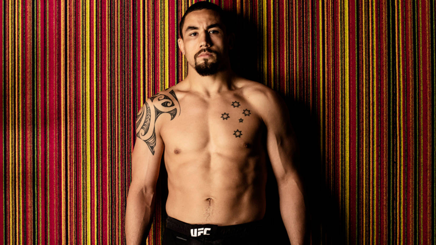 Robert Whittaker Against Colorful Striped Wall Background