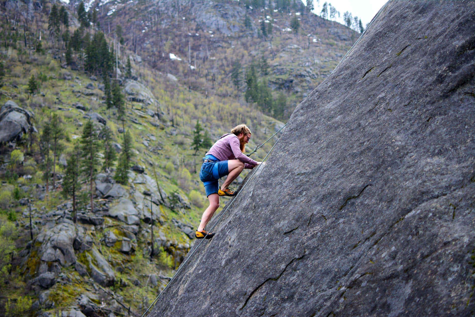 Rock Climber Ascending Steep Cliff Background