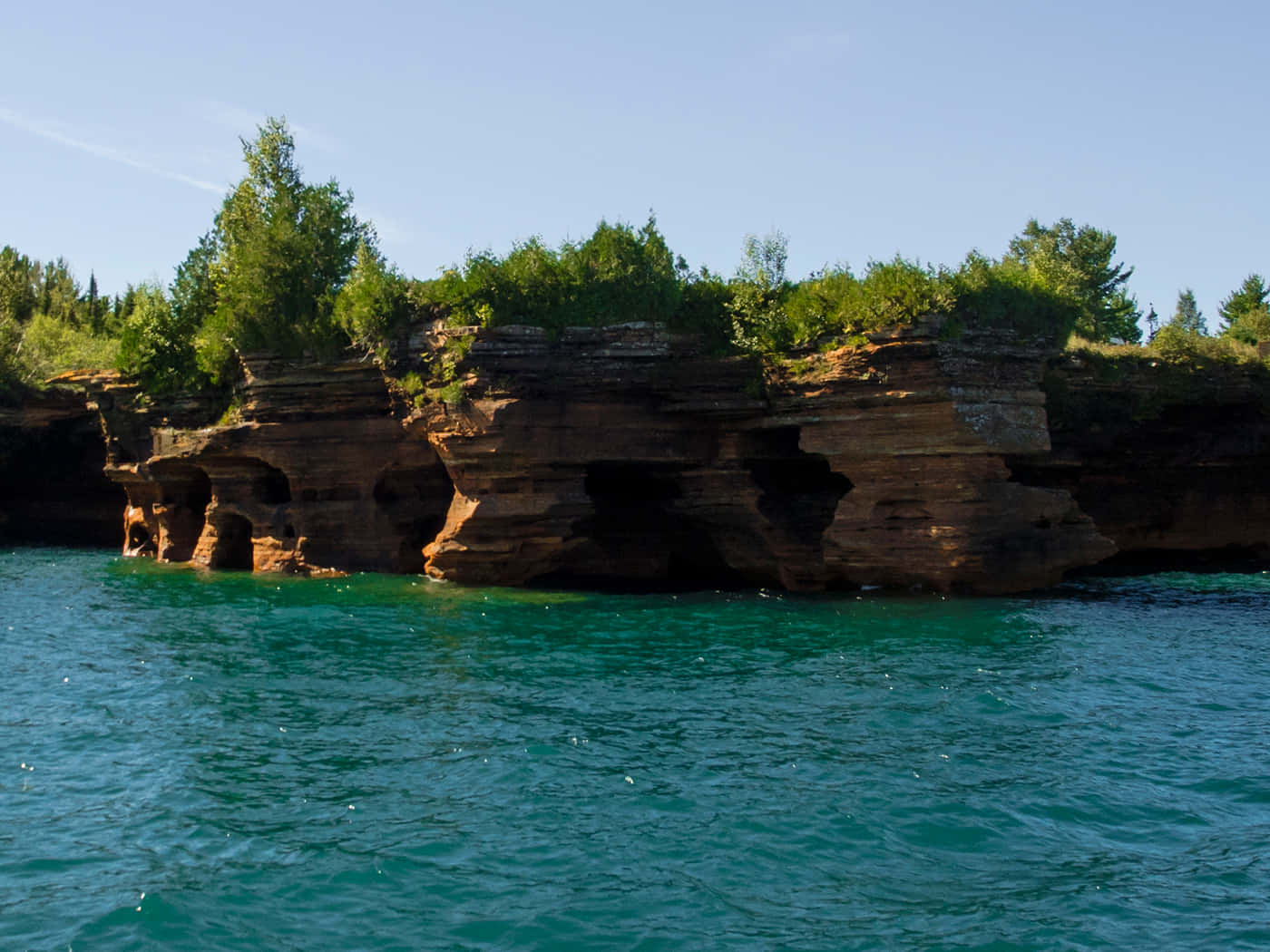 Rocky_ Cliffside_ Over_ Turquoise_ Water Background