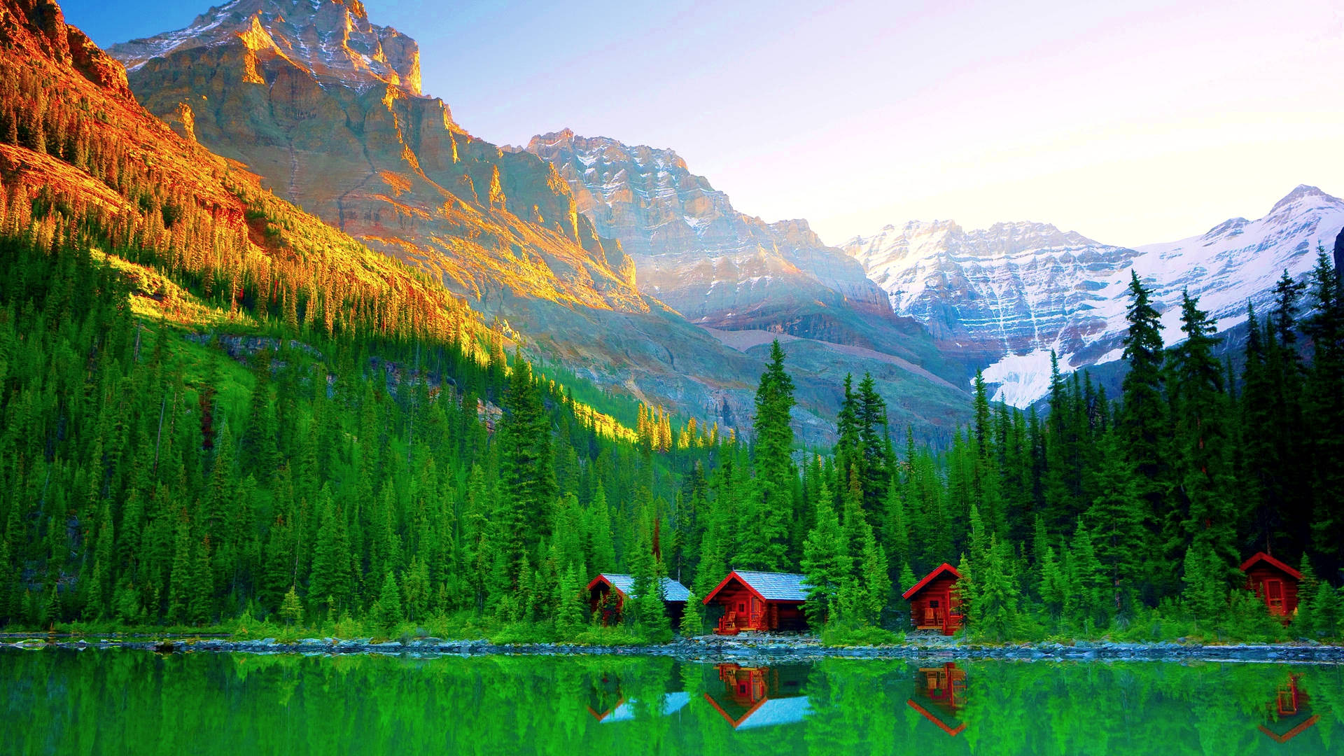 Rocky Mountain Behind Log Cabins By The Lake Background