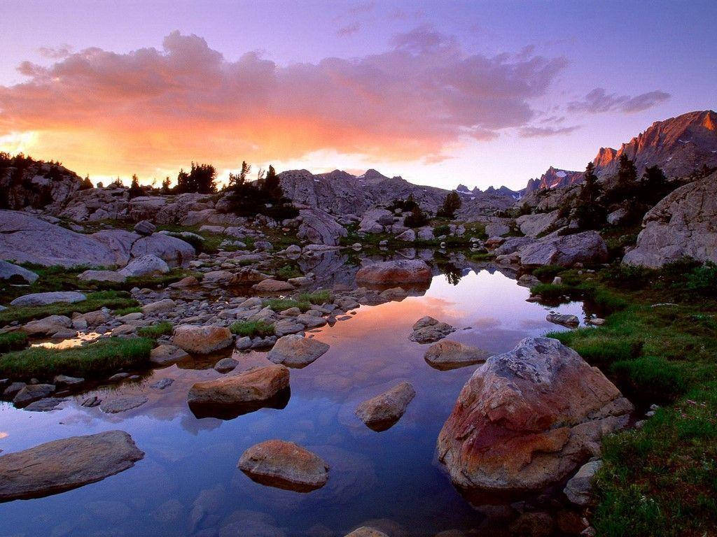 Rocky Mountain With Boulders Scattered Across The River