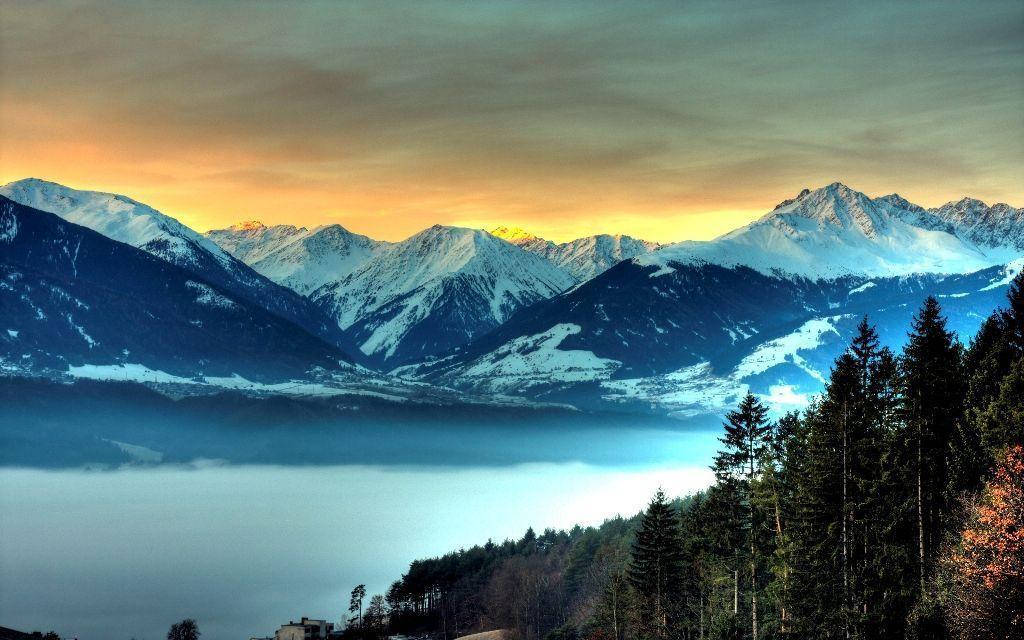 Rocky Mountain With Orange Sky Overhead Background