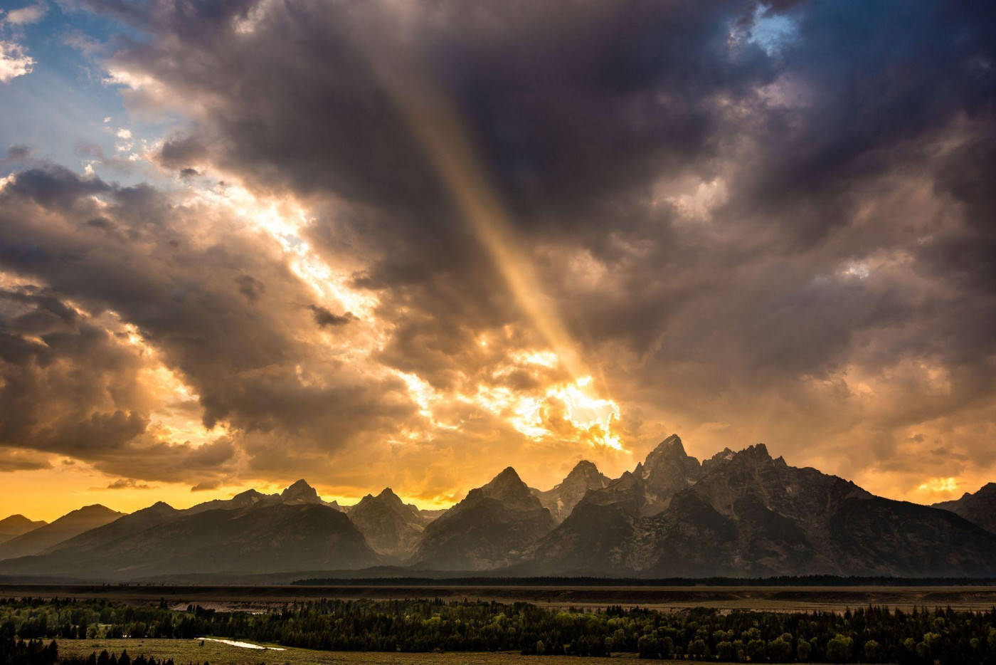 Rocky Mountain With Setting Sun And Clouds