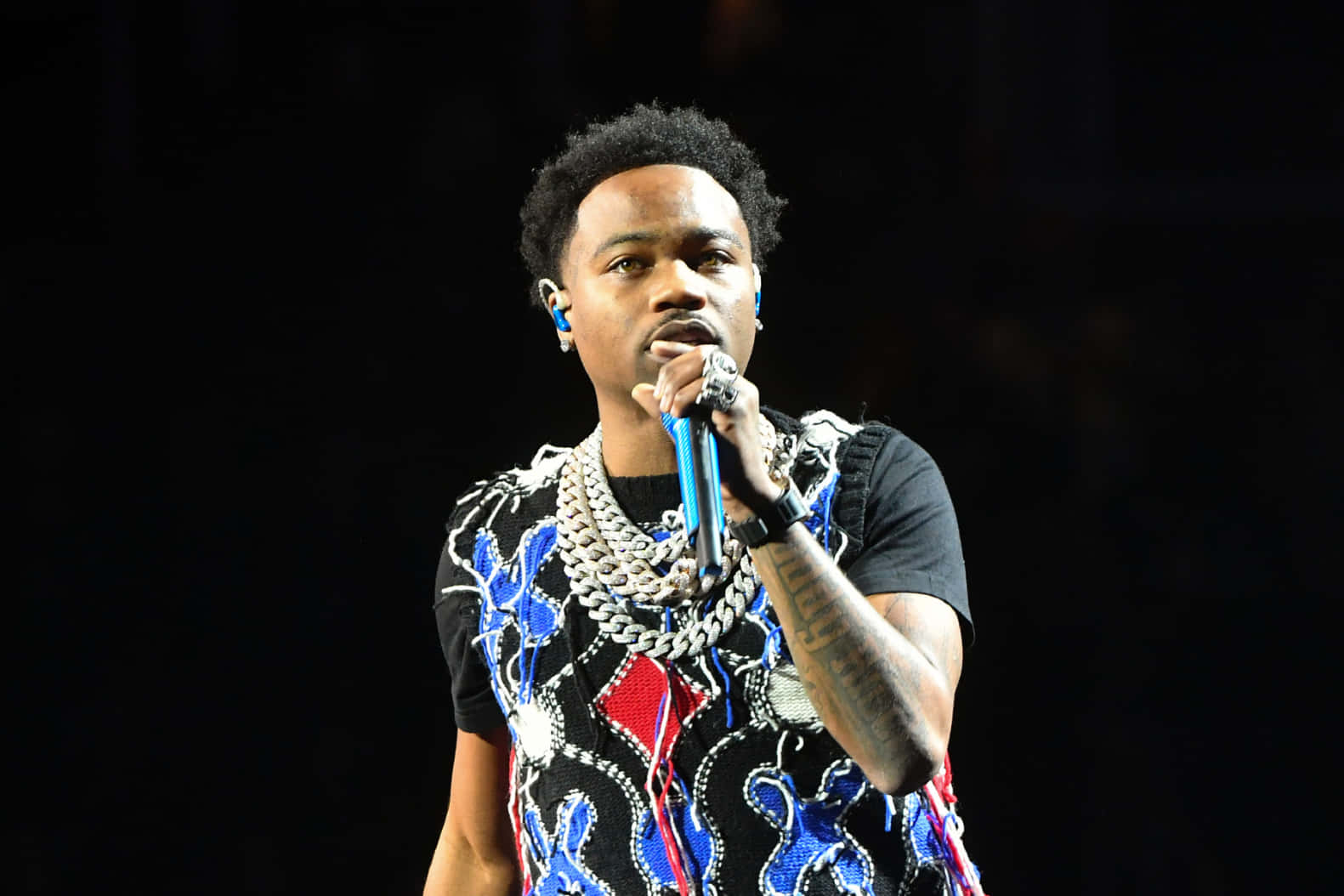 Roddy Ricch Strikes A Pose During A Performance Background