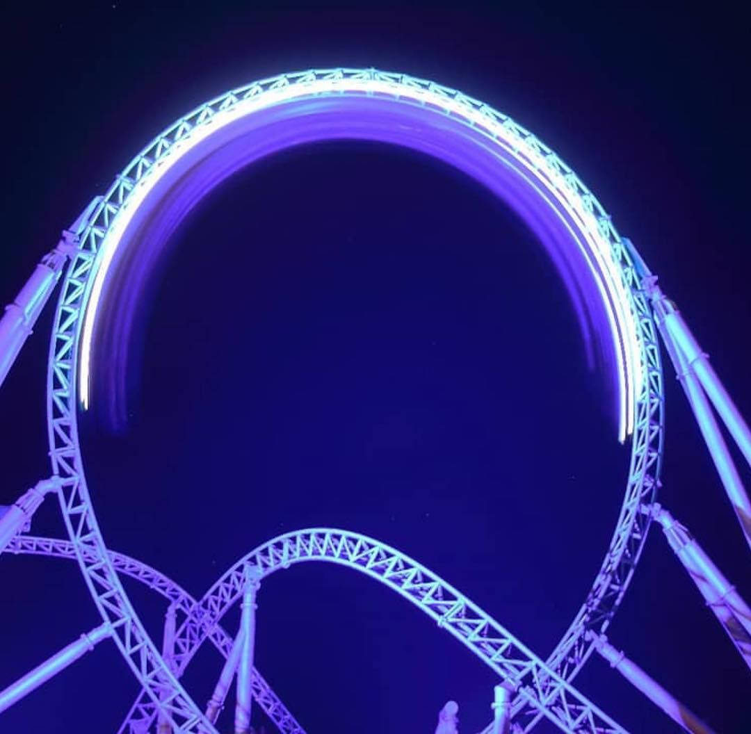 Roller Coaster In Glowing Purple Light Background