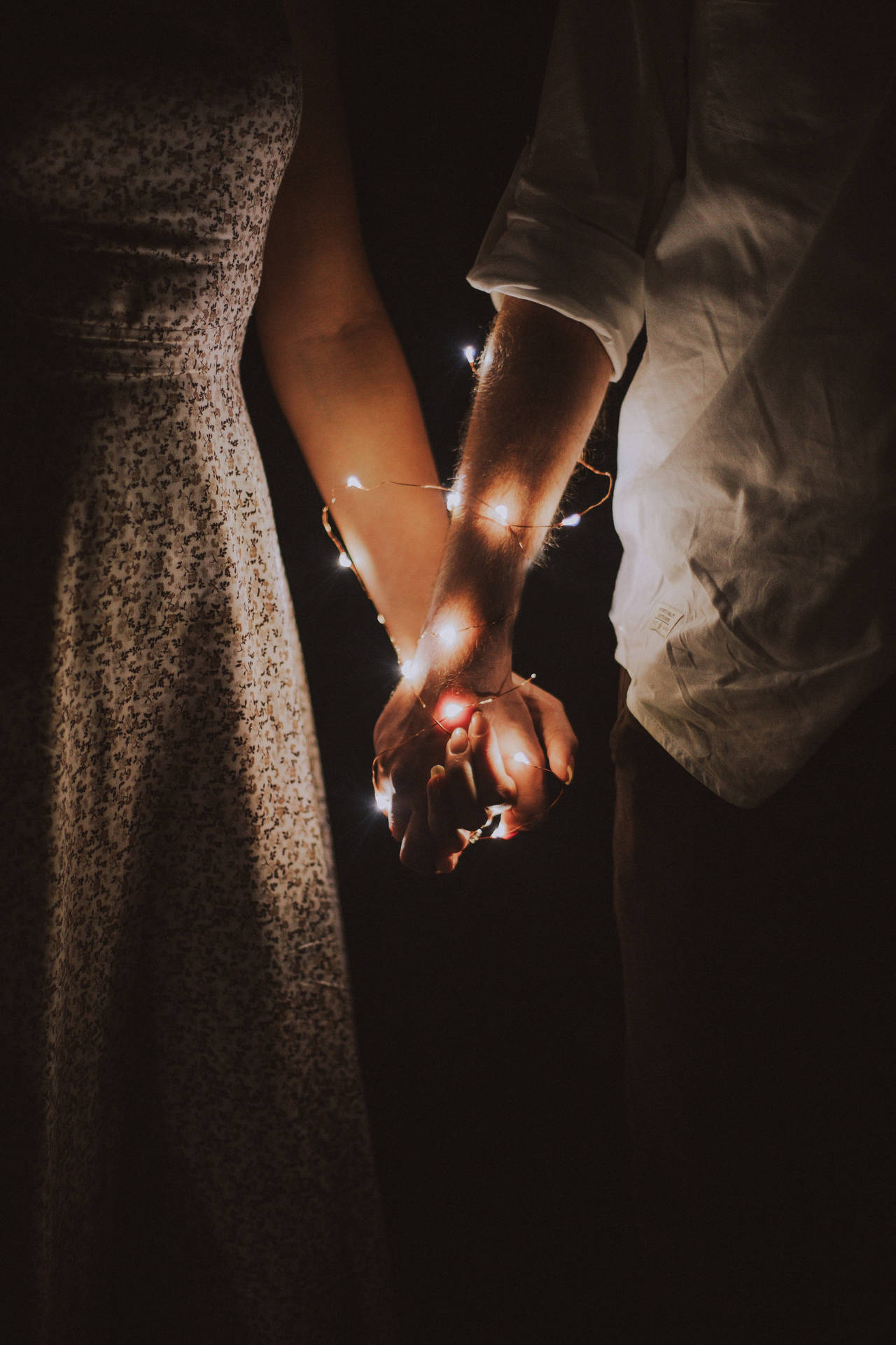 Romantic Couple Holding Hands With Fairy Lights
