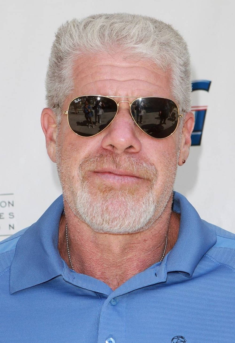 Ron Perlman In Blue Buttoned Polo Background