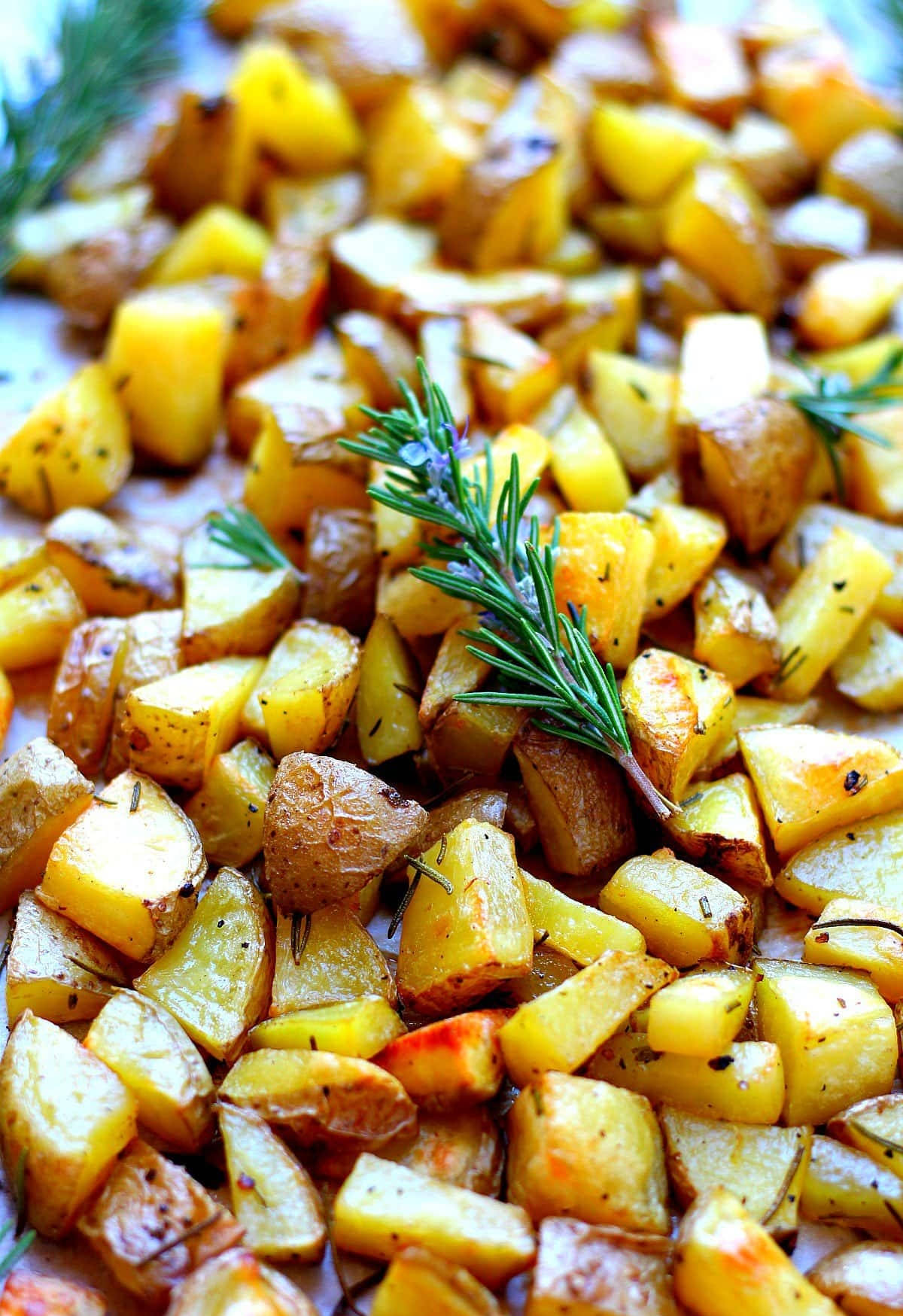 Rosemary Herb Sprinkled On Golden Baked Potato Wedges Background