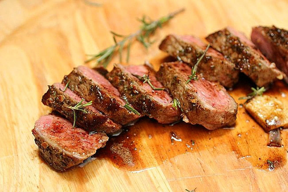 Rosemary With Medium Rare Steak Slices Background