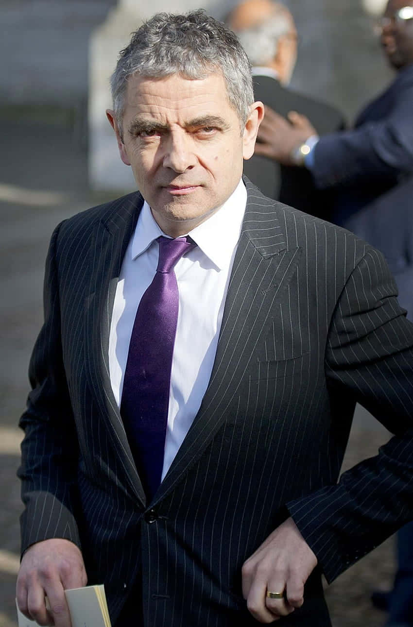 Rowan Atkinson Serious Businessman Look Background