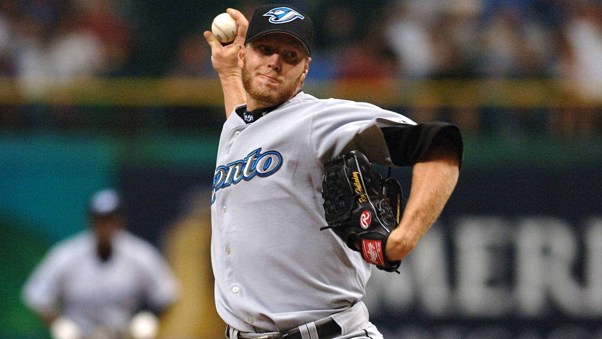 Roy Halladay Throwing Baseball While Holding Glove Background