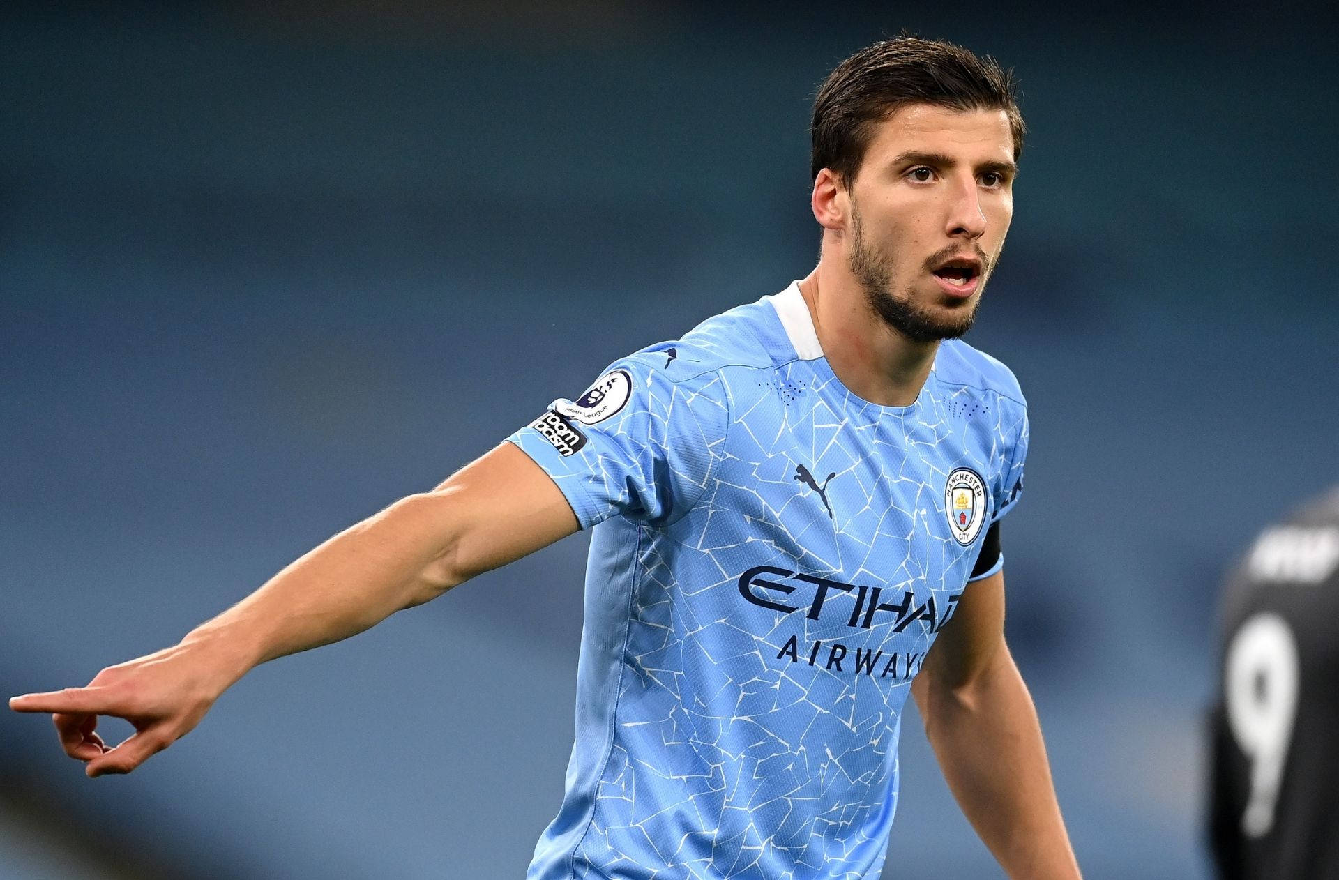 Ruben Dias Pointing On The Ground Background