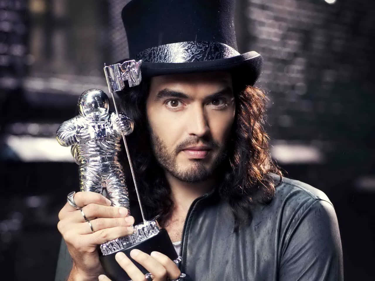 Russell Brand Triumphantly Holding An Mtv Award Trophy Background