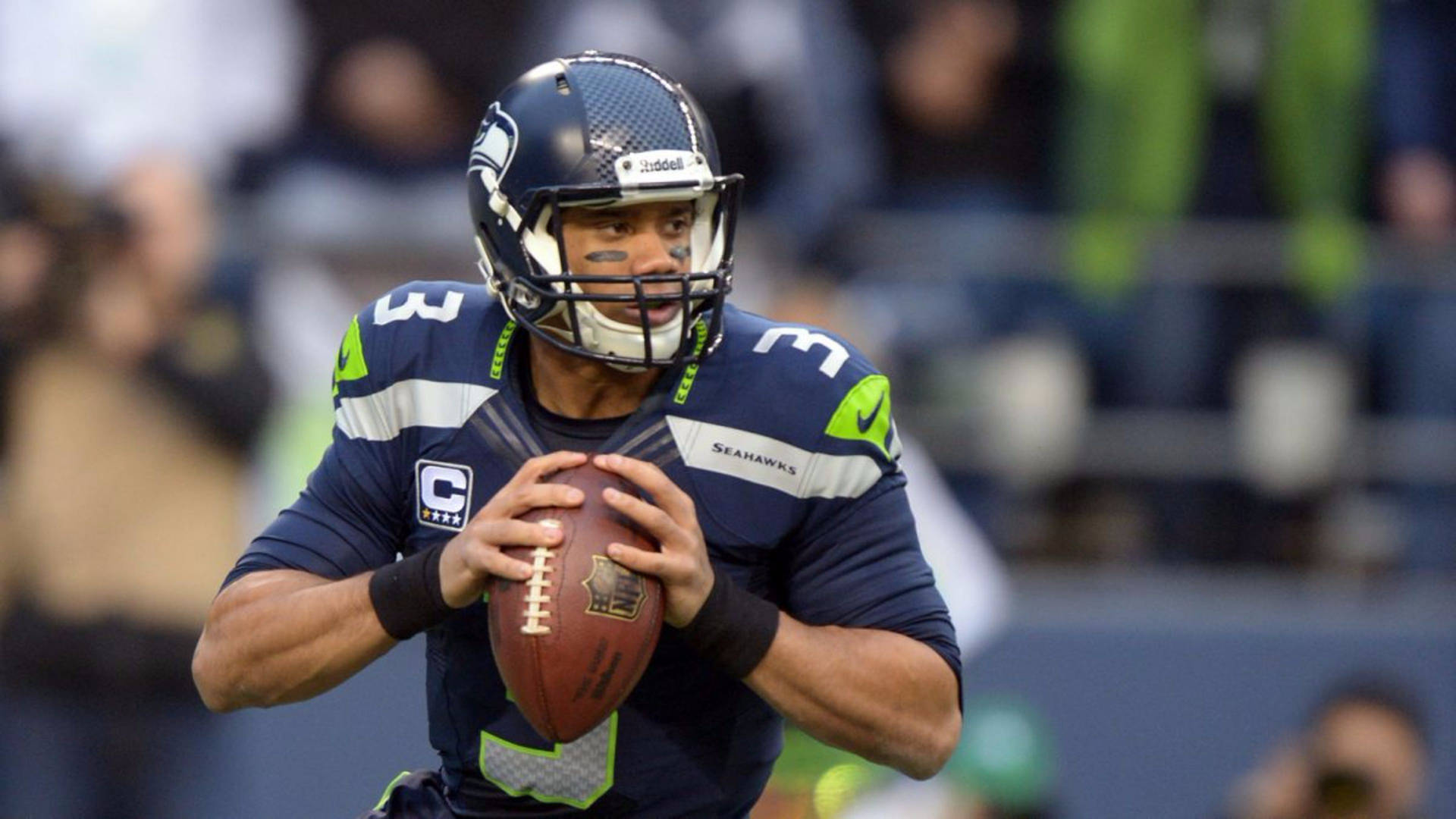 Russell Wilson Gripping Football Background