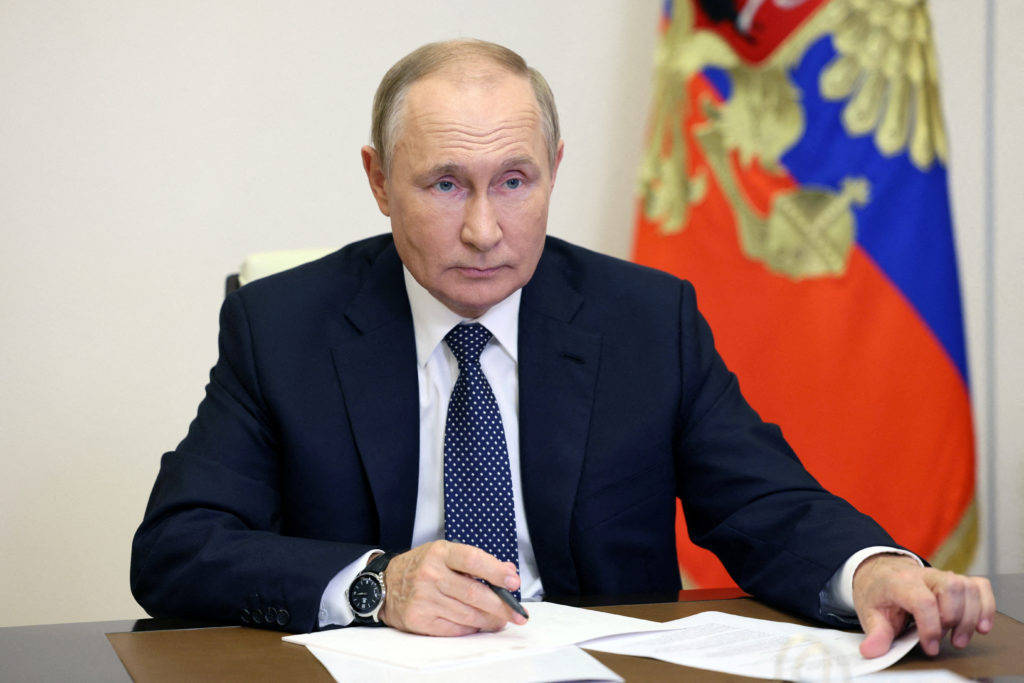 Russian President Vladimir Putin Seated At Meeting Table With Notes