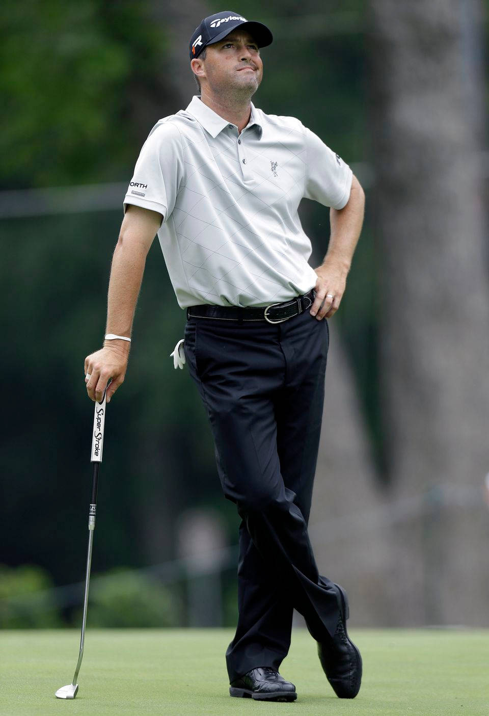 Ryan Palmer Looking Up Leaning On Golf Club Background