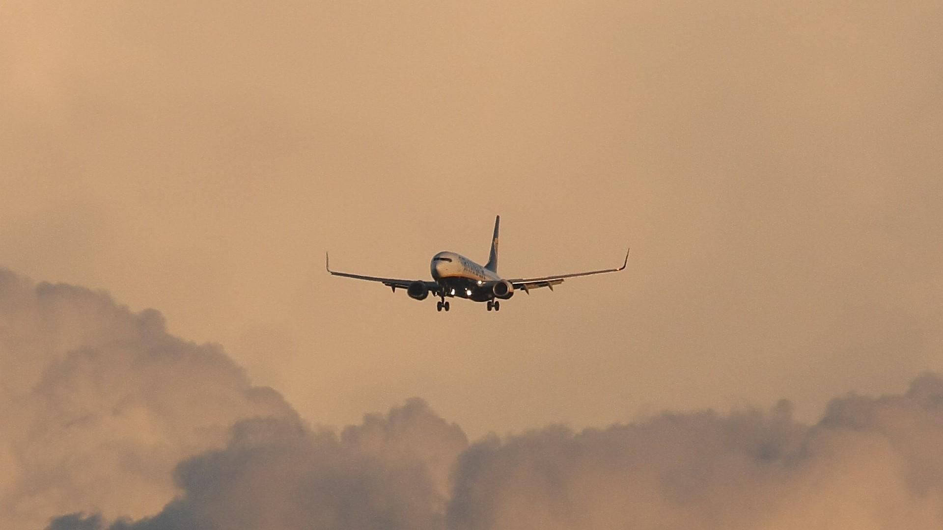 Ryanair Airplane Over Cloudy Orange Sky Background