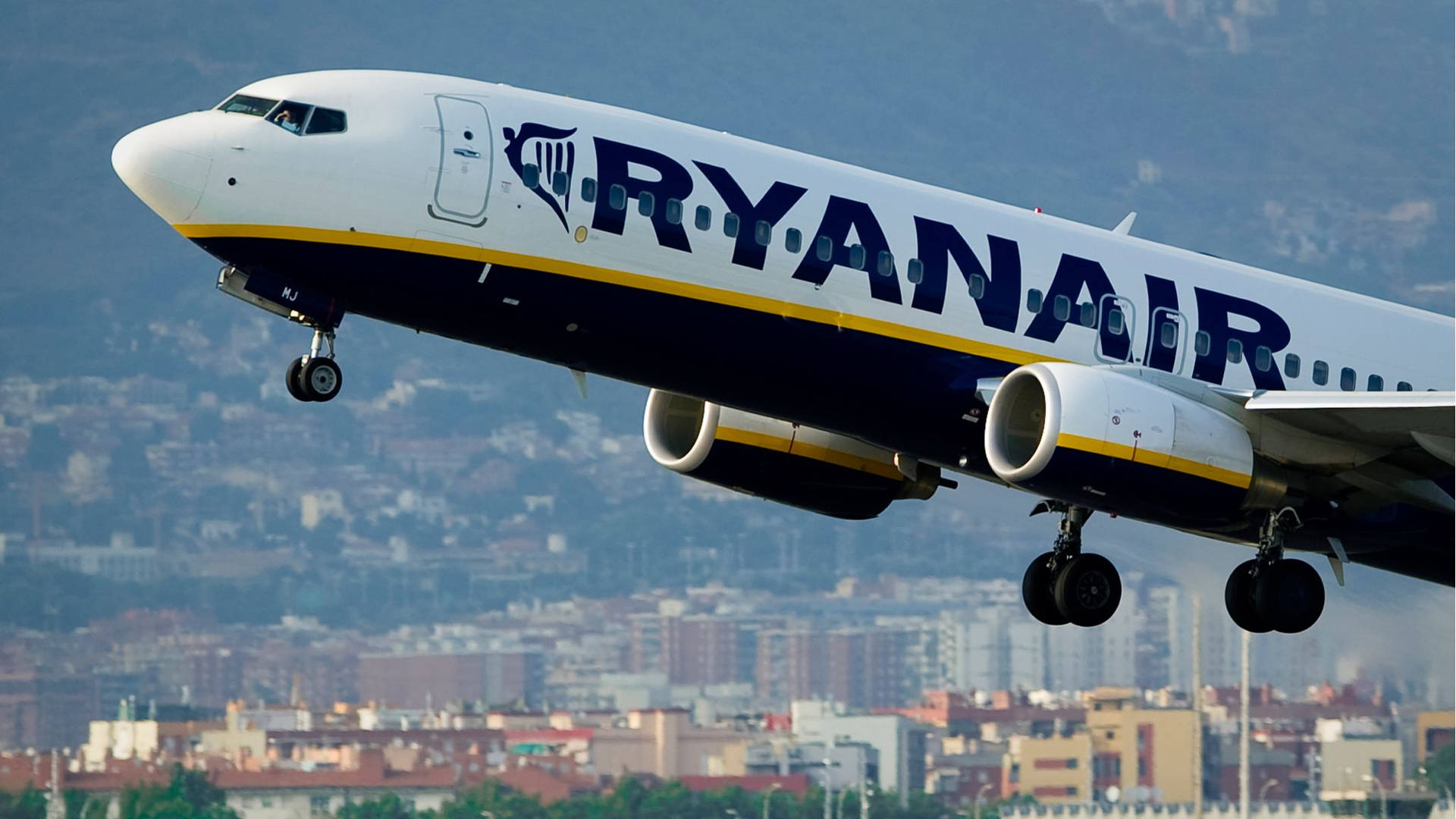 Ryanair Flying Over The City Background