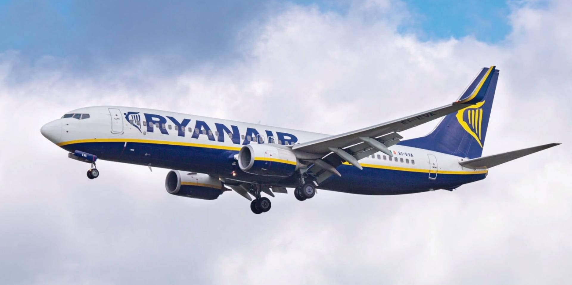 Ryanair Flying With Clouds Behind It Background