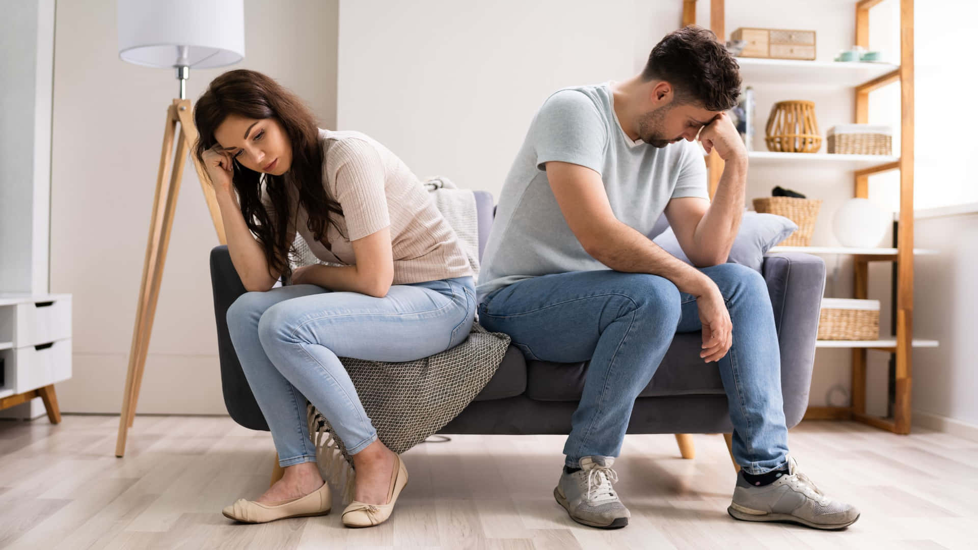 Sad Couple Sitting On The Couch Background