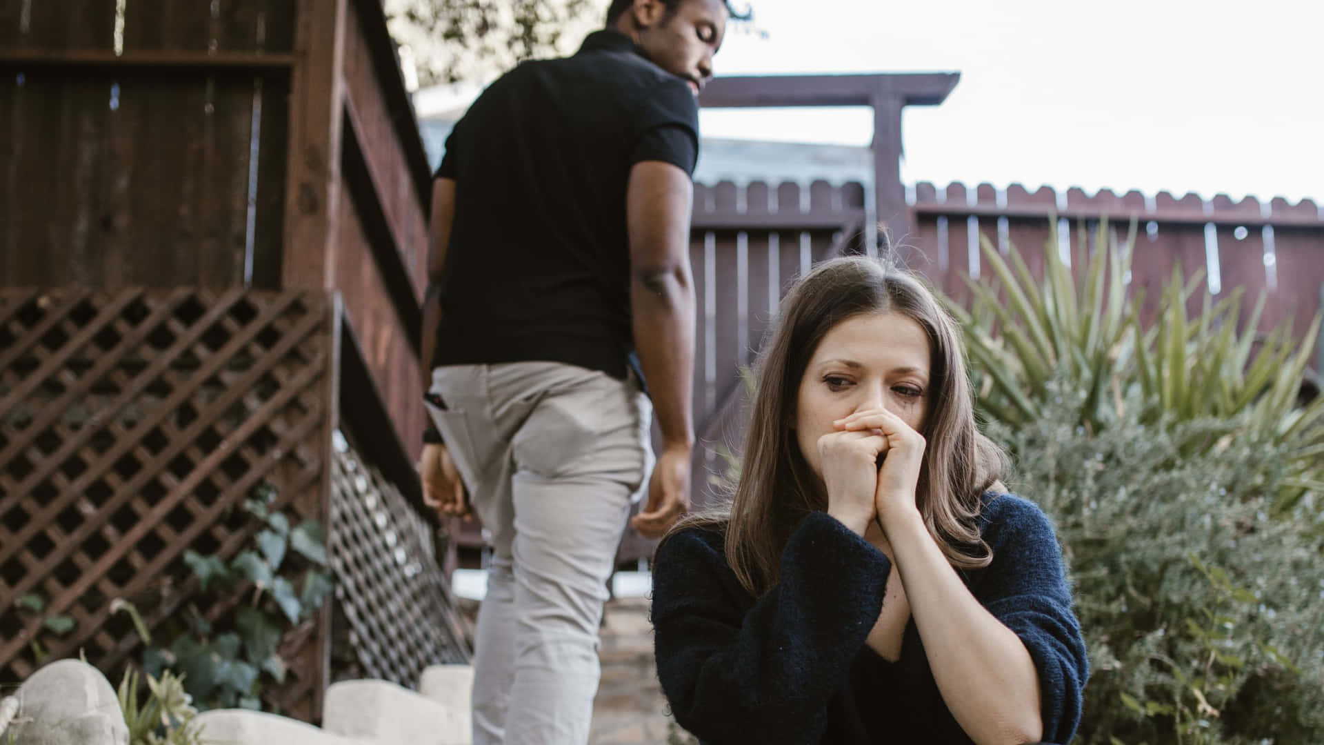 Sad Couple Sitting On The Stairs Background