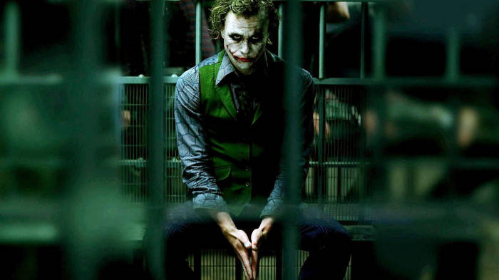 Sad Joker Behind Bars Background