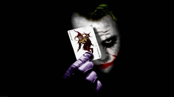 Sad Joker Holding A Playing Card Background