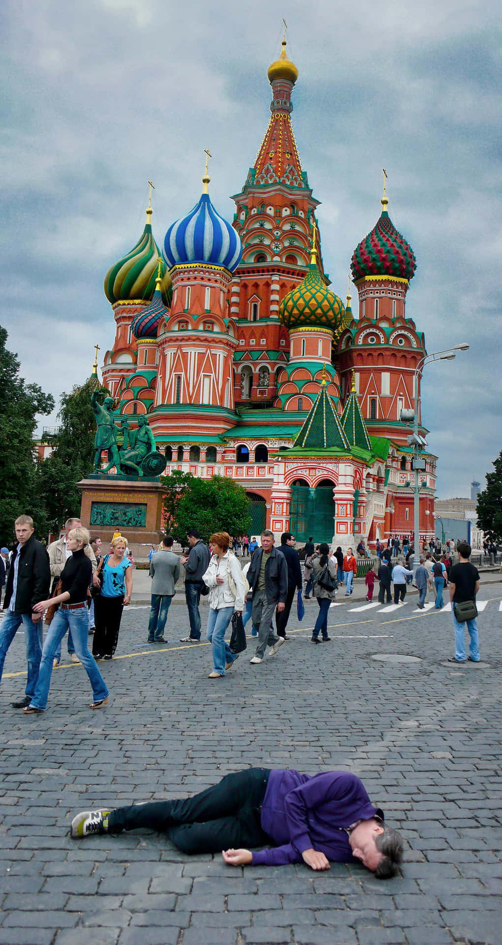 Saint Basil's Cathedral With Man Lying On The Ground Background