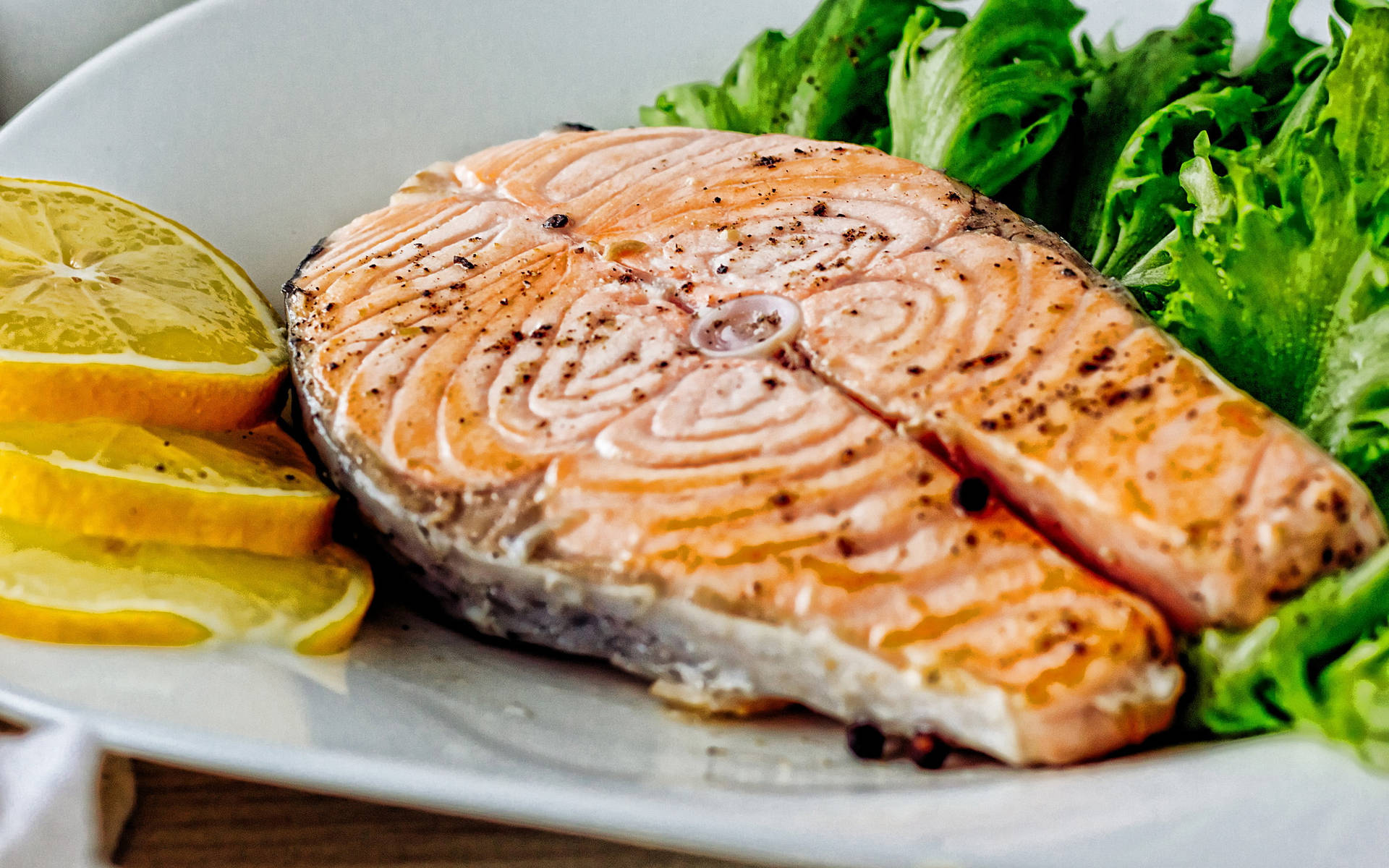 Salmon Steak With Greens And Lemon Slices Background