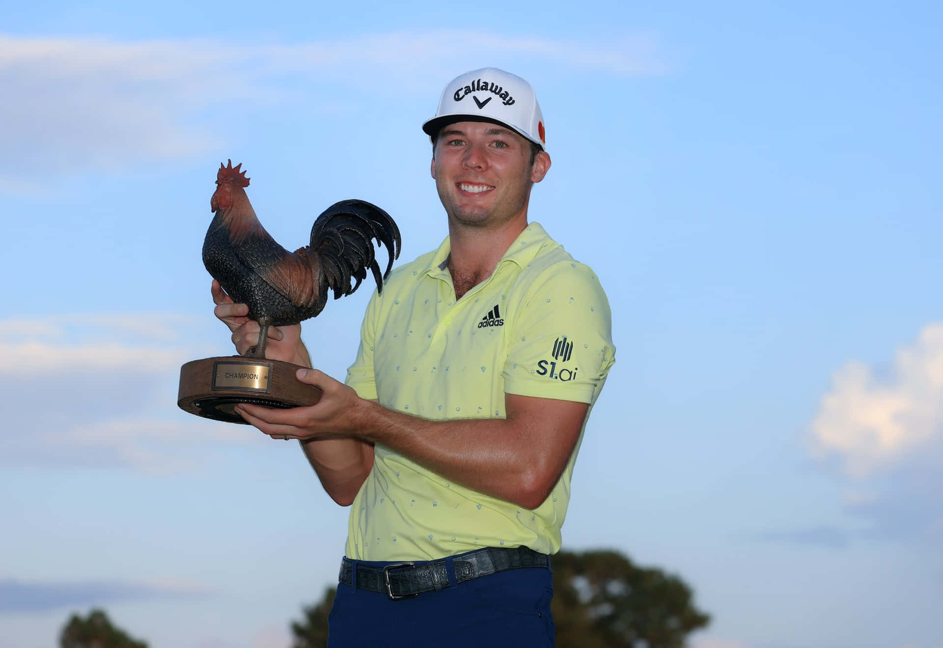 Sam Burns Holding The Sanderson Farms Championship Trophy Background