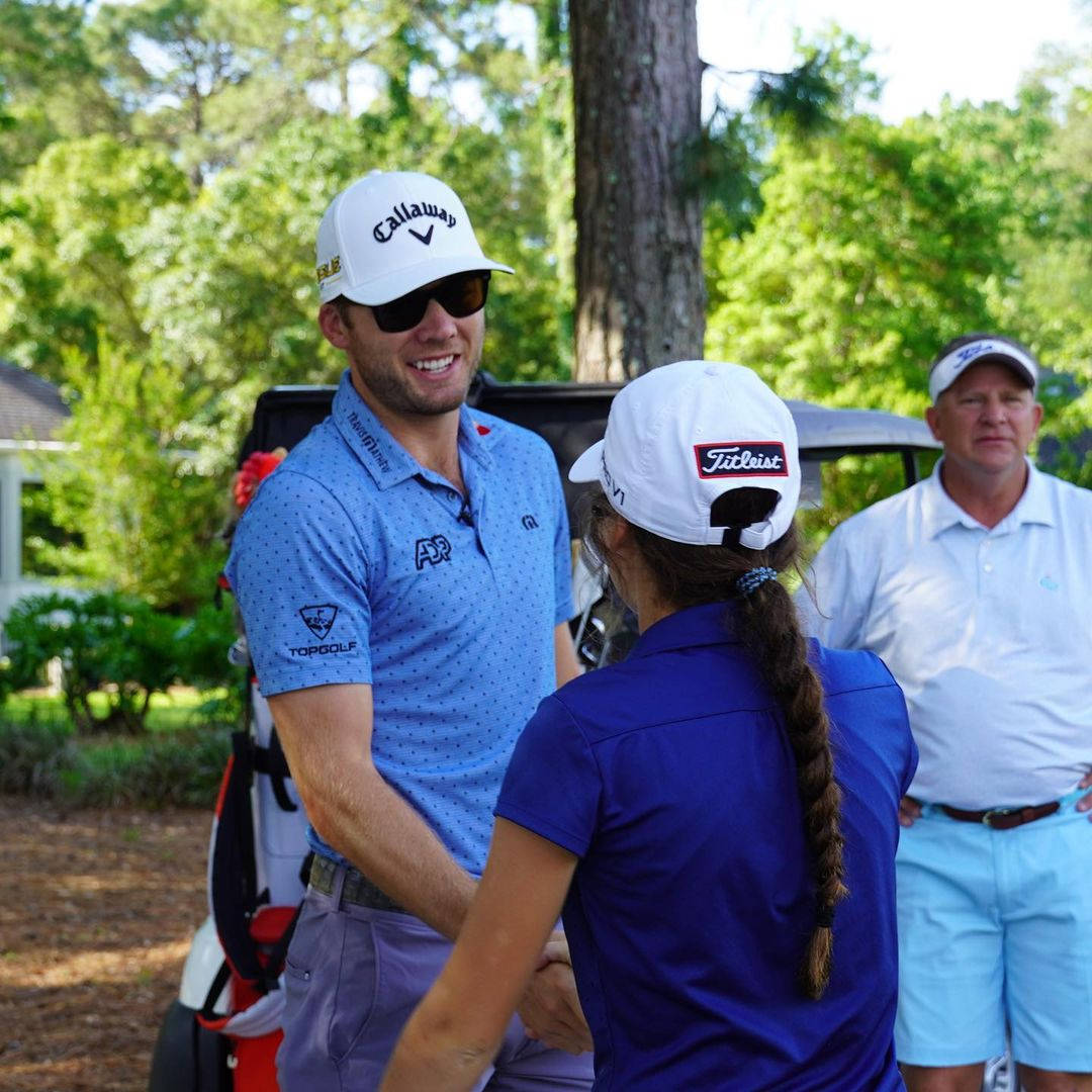 Sam Burns Shaking Hands With Woman Background