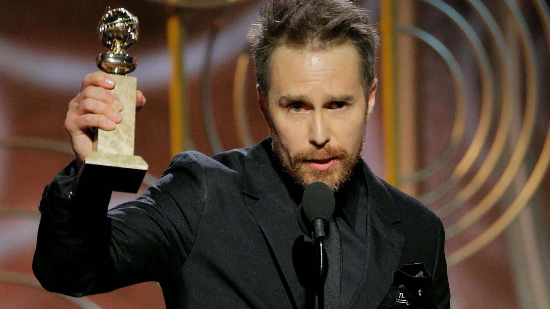 Sam Rockwell Exuding Charm With His Golden Globe Trophy Background