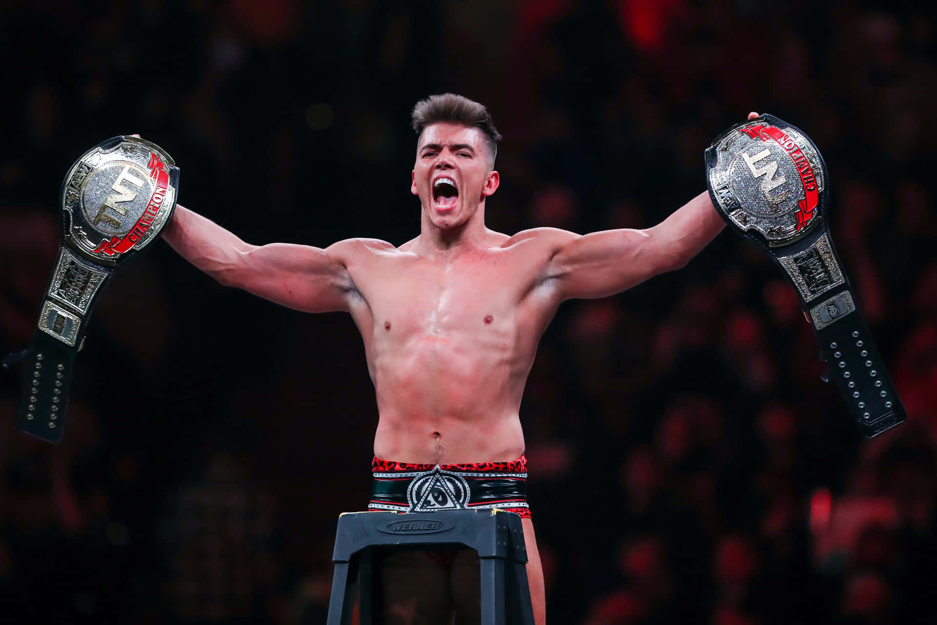 Sammy Guevara With His Championship Belts Background