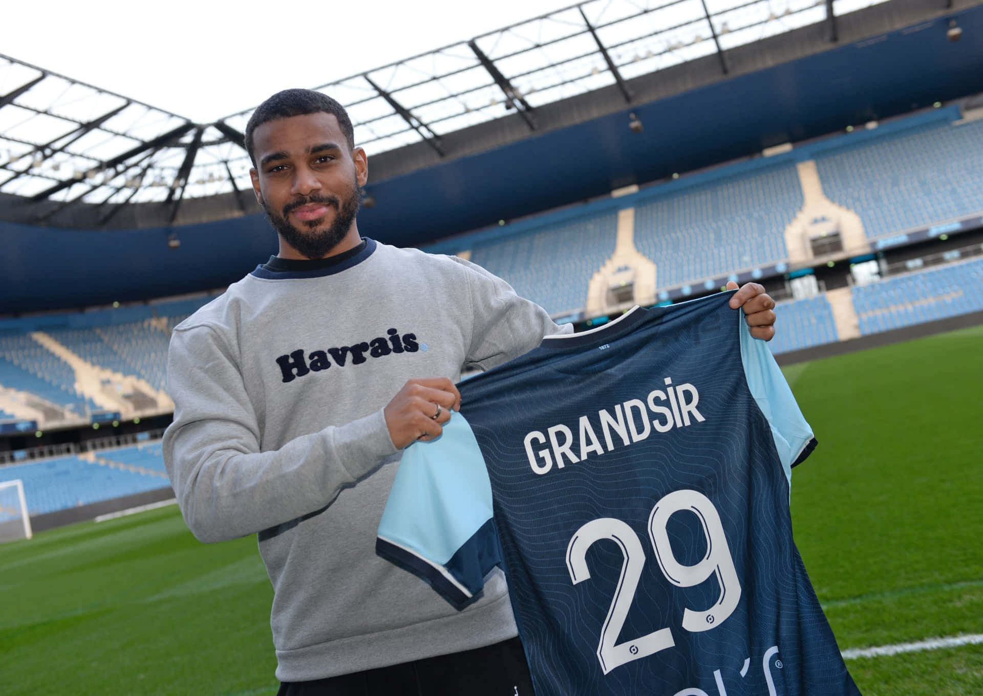 Samuel Grandsir Holding Jerseyat Stadium Background