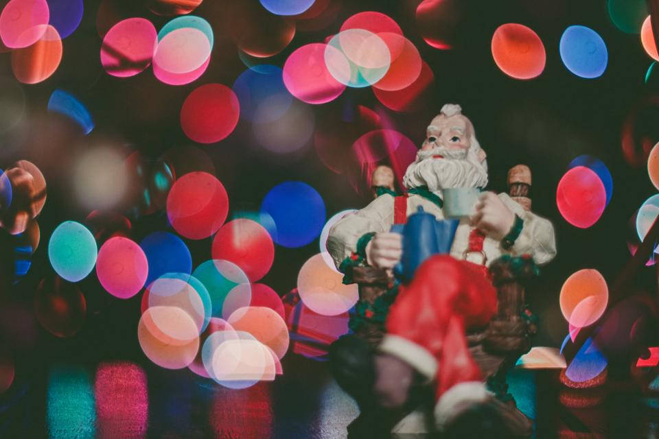 Santa Figurine And Colorful Christmas Lights Background