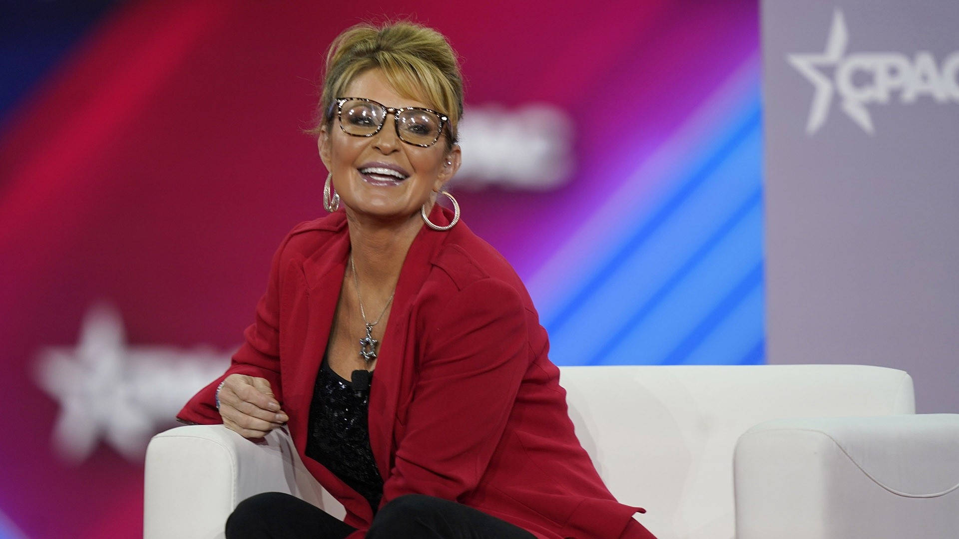 Sarah Palin Relaxing On A White Couch Background