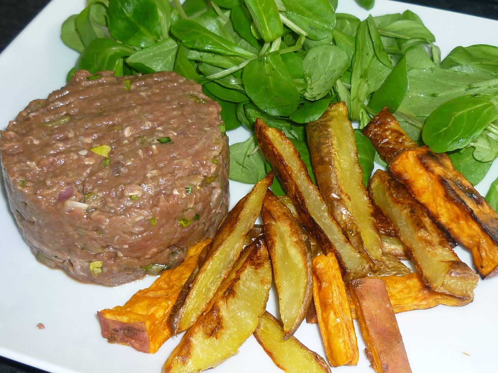 Savor The Delicacy Of Steak Tartare Served With Golden Potatoes Background