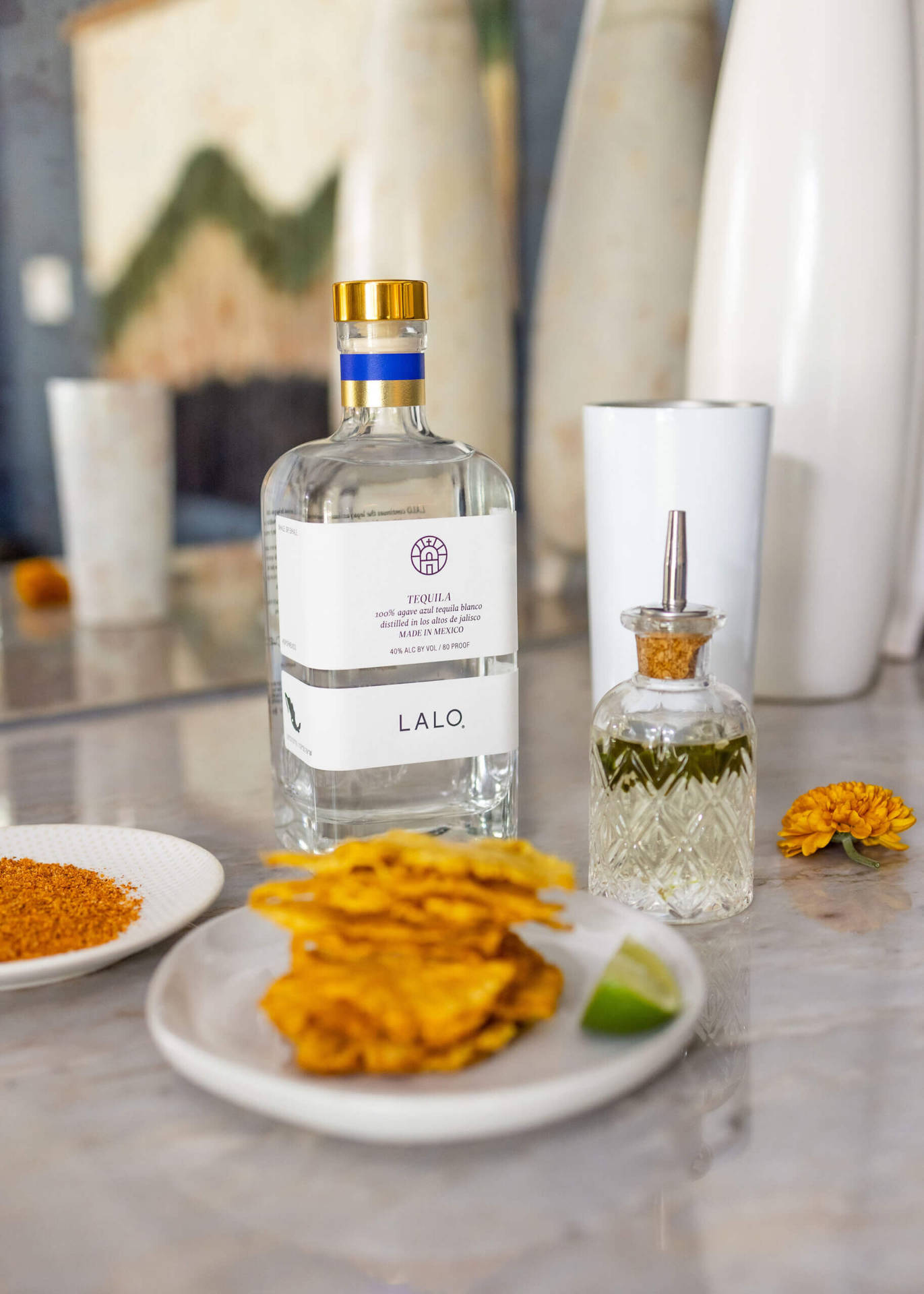 Savor The Essence Of Lalo Tequila Paired With Crispy Snacks Background