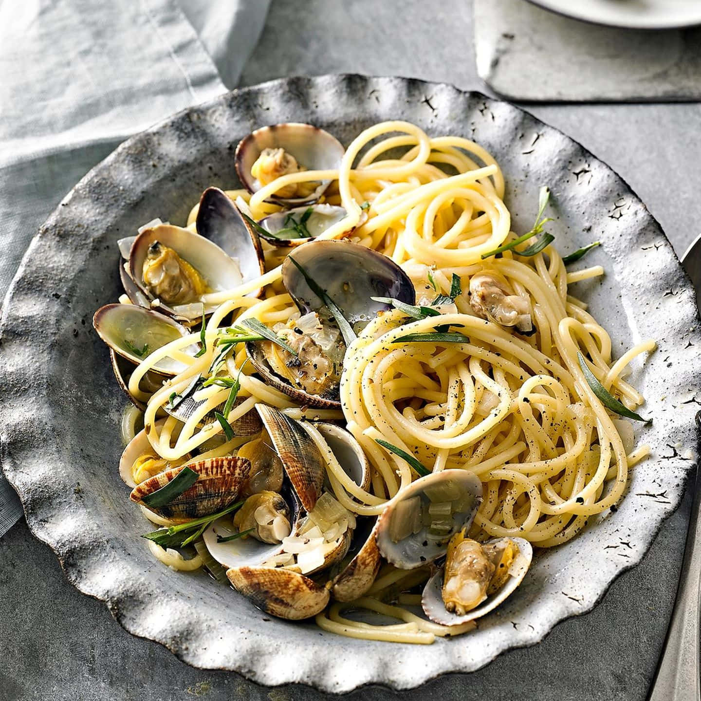 Savory Spaghetti Alla Vongole Served On A Rustic Plate Background
