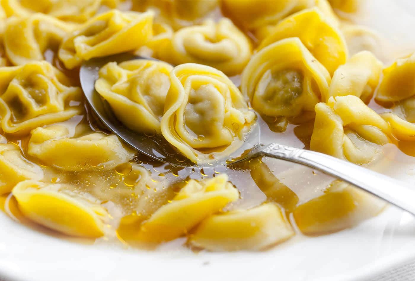 Savory Spoonful Of Tortellini In Brodo Background