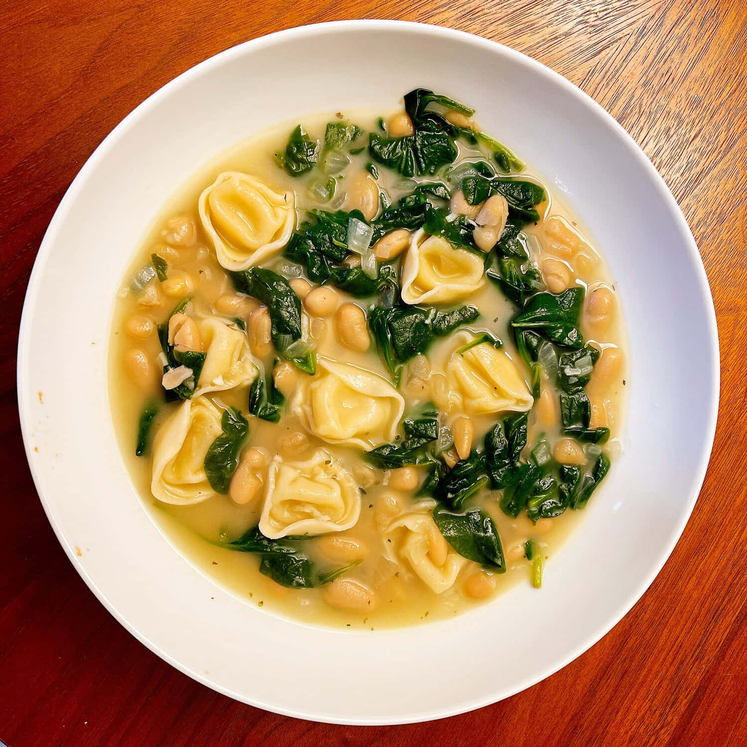 Savory Tortellini In Brodo With Spinach And Legumes Background