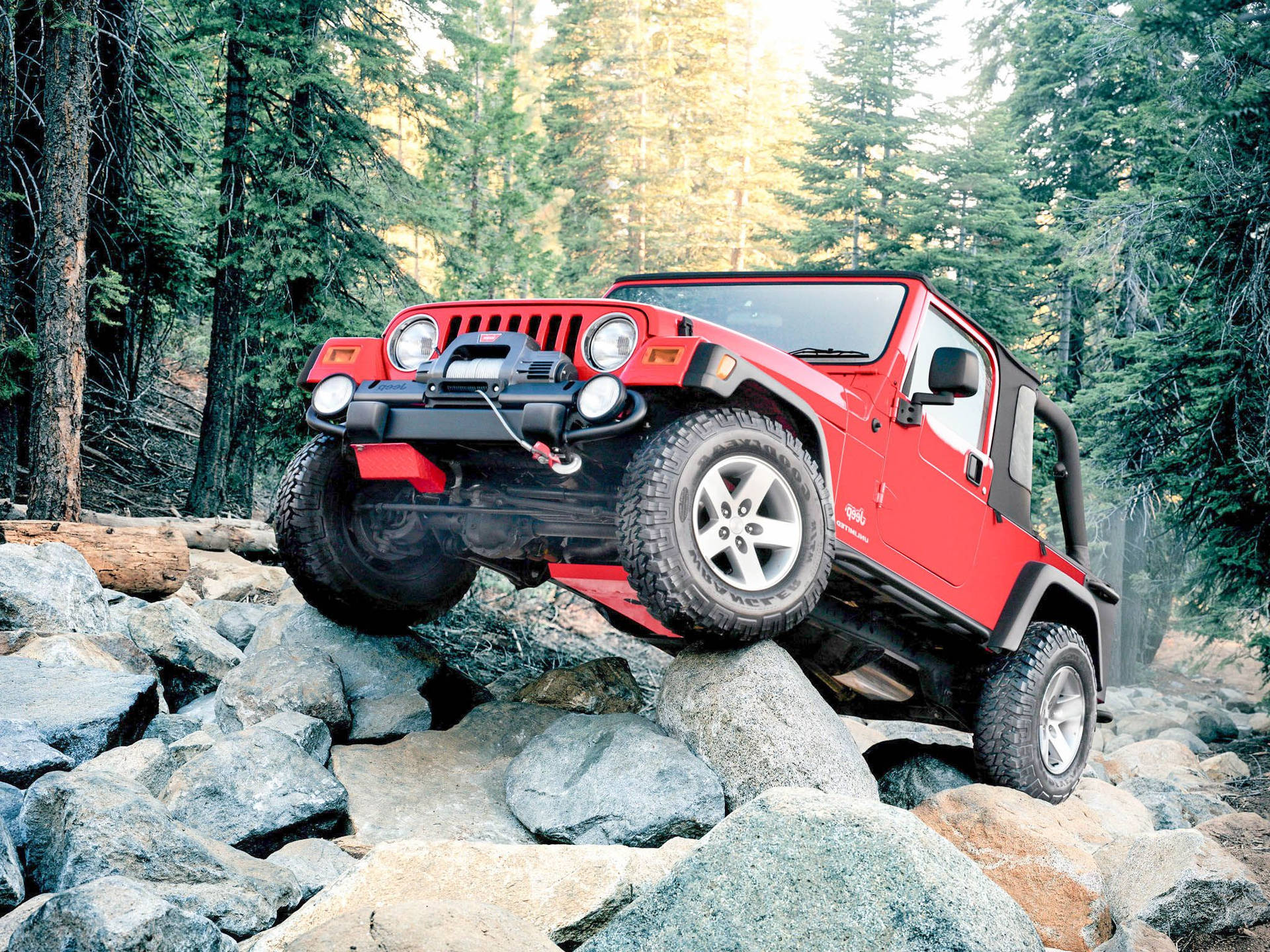 Scarlet Jeep In Rocky Forest Background