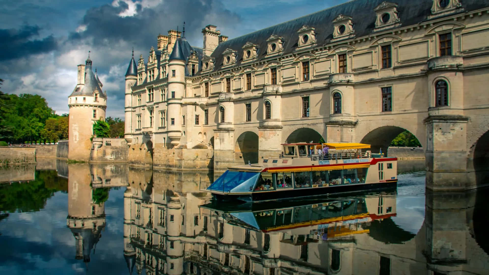 Scenic View Of A Boat Passing Under The Historic Chenonceau Castle Background