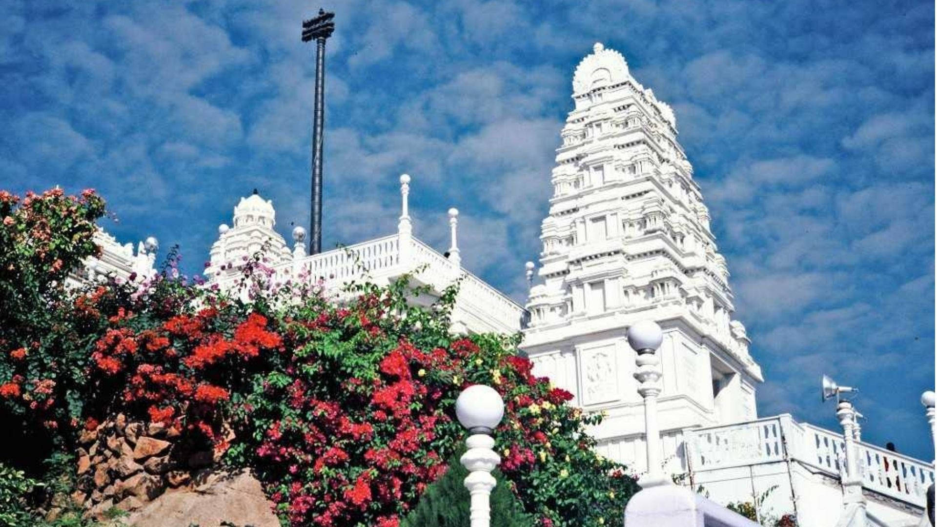 Scenic View Of Birla Mandir In Hyderabad Surrounded By Beautiful Blooms Background